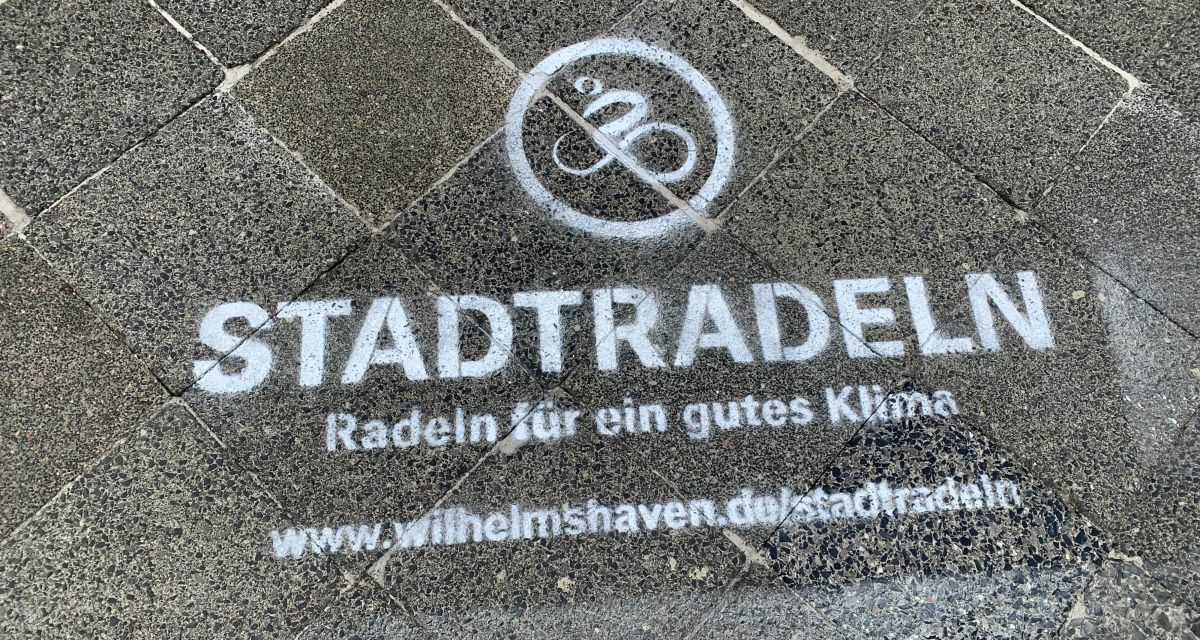 Auf dem Foto ist ein auf Gehweg-Steinen der weiße, aufgesprühte Schriftzug 