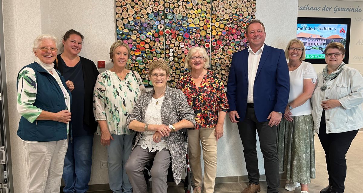 Der Kunst- und Kulturkreis überreichte am Mittwoch (16.07.2025) ein Kunstwerk an Bürgermeister Helfried Goetz. Es ist ein dreiteiliges Kunstwerk, bestehend aus 500 bemalten Holzscheiben. Vor dem Kunstwerk, das nun im Eingangsbereich des Rathauses hängt, sind zu sehen: (von links) Johanna Bleeker, Julia Stamm, Ilse Weers-Dirks, Annemarie Gellermann, Ruth Thurm, Bürgermeister Helfried Goetz, Monika Reuß und
Corinna Schumacher