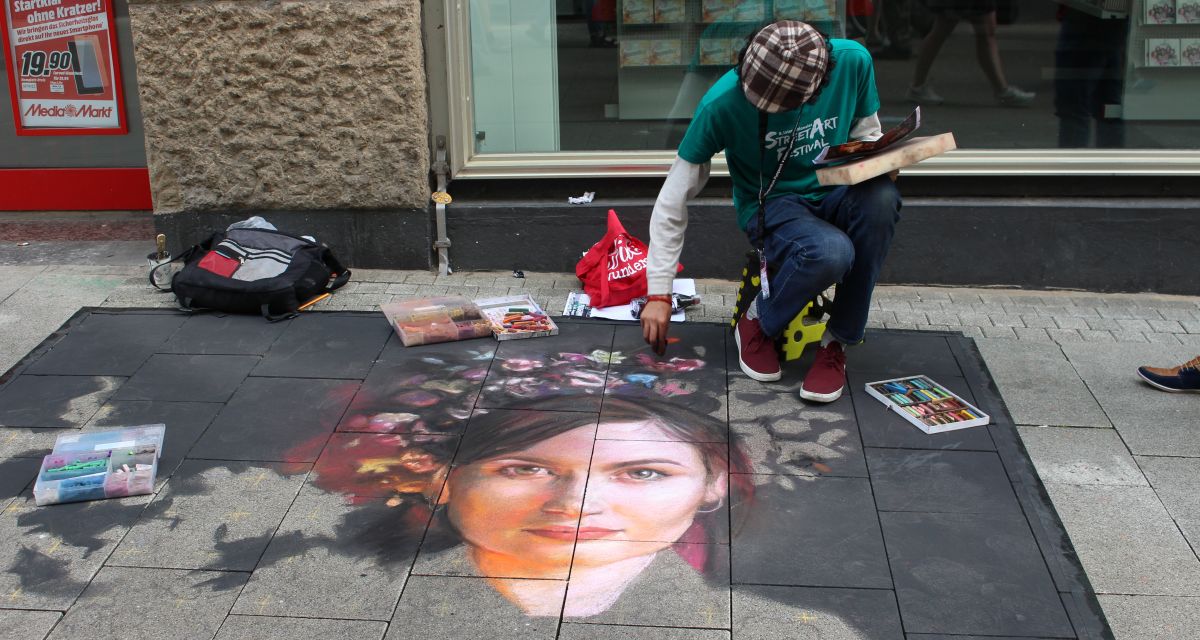 Ein Kunstwerk auf dem Boden der Wilhelmshavener Innenstadt, der Künstler malt noch daran.