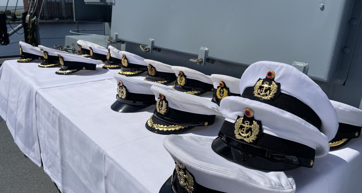 Mützen der Marine liegen an Board einer Fregatte.