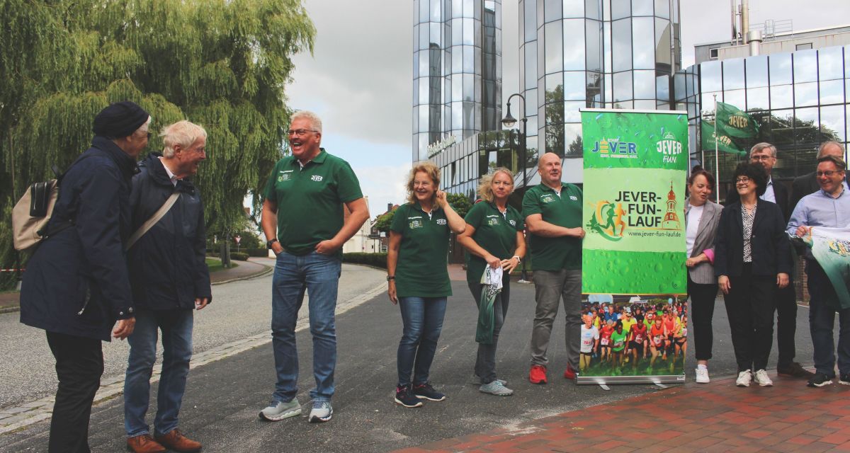 Zwei Passanten schnacken mit einem der Organisatoren des Jever Fun Laufs 
