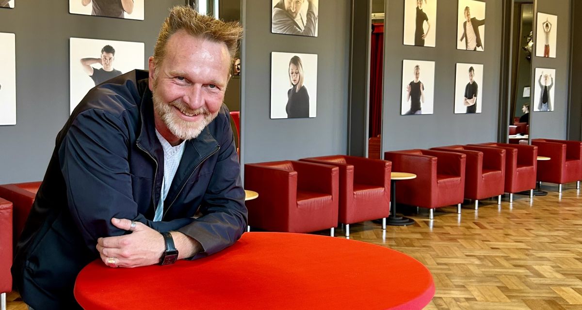 Zu sehen ist Olaf Strieb, Intendant derlalndesbuhne im obreen Foyer des Wilhelmshavener Stadttheaters an eienem Stehtisch.