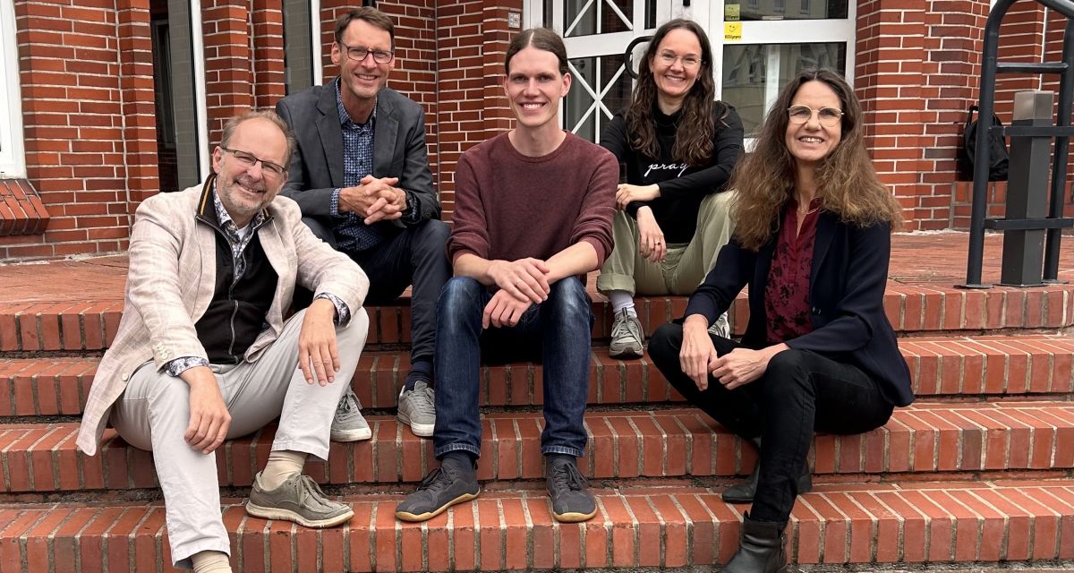 Das bPfarrteam Neuende/Bant sitzend auf der Treppe vor dem banter Gemeindehaus. V.l.n.r.:
Stephan Stalling, Klaus Eldert Müller (Kantor), henry Burow; Juliane Ost, Anke Stalling