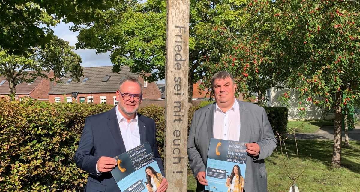 Die Telefonseelsorge Friesland-Wilhelmshaven sucht neue Ehrenamtliche, die sich in einer einjährigen Ausbildung zu Telefonseelsorger*innen weiterbilden lassen. Dazu stellten der Kreispfarrer Christian Scheuer (links) und Wilhelmshavens Oberbürgermeister Carsten Feist (rechts) die Kampagne vor. Das Foto wurde vor dem Diakonischen Werk Wilhelmshaven aufgenommen. Scheuer und Feist stehen neben einer Stele mit der Aufschrift 