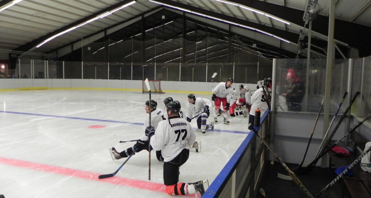 Eishockeyspieler in Aktion in einer Eishalle.