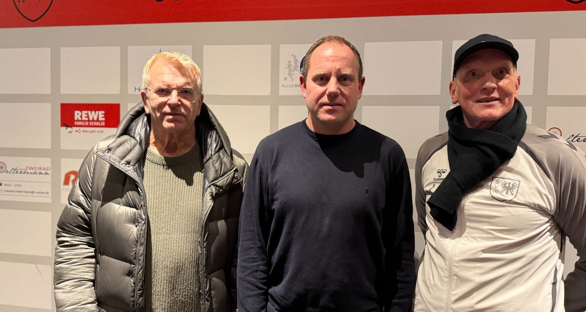 Drei Männer vor Sponsorenwand