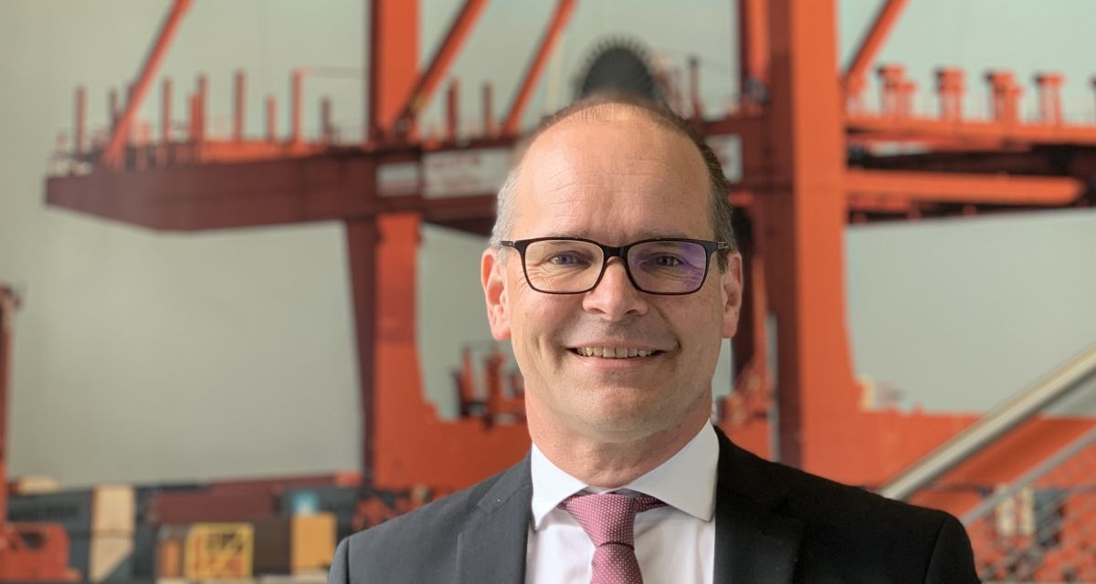 Zu sehen ist Grant Hendrik Tonne. Seit Mitte Mai 2025 ist er Wirtschaftsminister des Landes Niedersachsen. Er folgte damit auf Olaf Lies nach dessen Wahl zum Ministerpräsidenten. Das Bild wurde im JadeWeserPort Info-Center aufgenommen, im Hintergrund ist das Wandbild eines Hafenkrans zu sehen. 