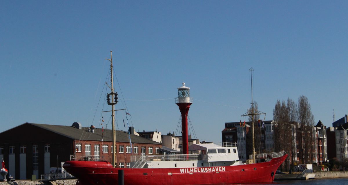 Zu sehen ist ein rotes Schiff mit der weißen Aufschrift 