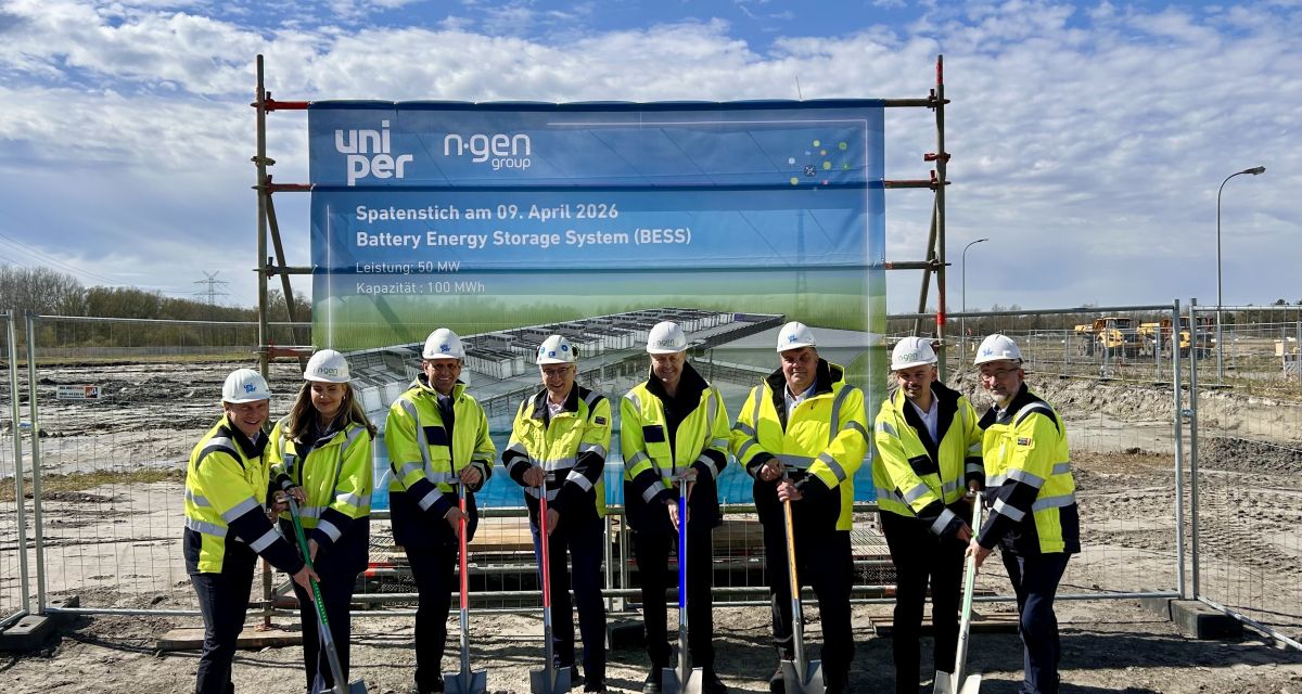 Zu sehen sind acht Menschen mit Helmen und Warnwesten beim symbolischen Spatenstich des batteriespeichers auf dem Gelände des Uniper-Kraftwerkes