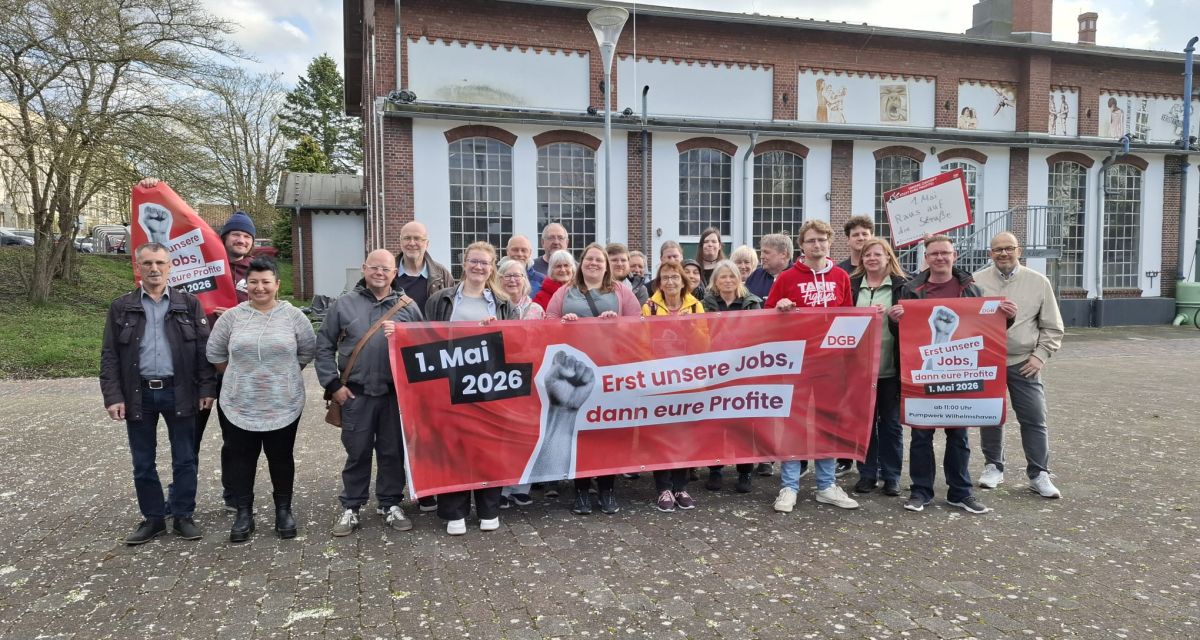 Initiator*innen der Maikundgebung zum Tag der Arbeit in Wilhelmshaven präsentieren sich mit Bannern und Plakaten vor dem Kulturzentrum Pumpwerk.