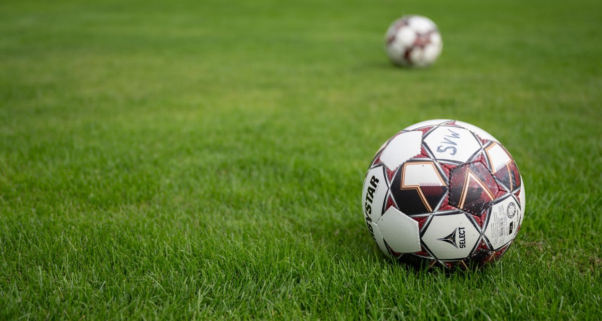 Zwei Fußbälle, einer mit der handschriftlichen Beschriftung 