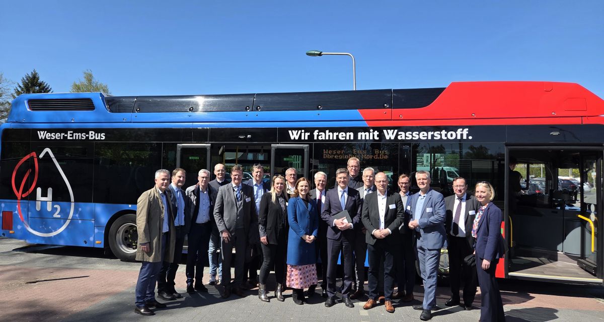 Der Parlamentarische Staatssekretär im Bundesverkehrsministerium Christian Hirte besucht die Metropolregion Nordwest. Er steht gemeinsm mit Vertreter*innen der Metropolregion vor einem Wasserstoffbus der Weser-Ems-Bus.