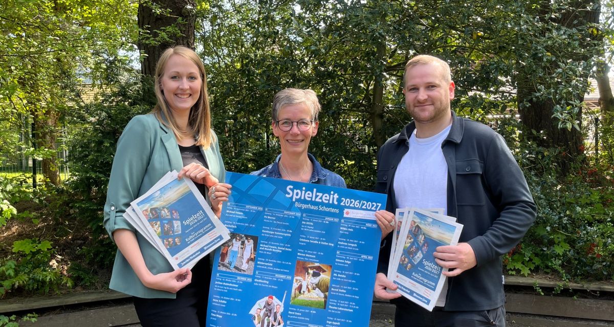 Zu sehen sind die Vertreter*innen aus dem Kulturbüro des Bürgerhauses Schortens (v.l.n.r. Lotta Klein, Carola Holm, Stefan de Buhr) mit dem Plakat der neuen Spielzeit.