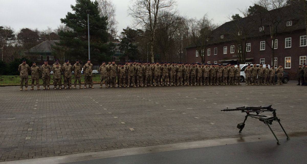 Soldaten beim Appell . Im Vordergrund ein Maschinengewehr