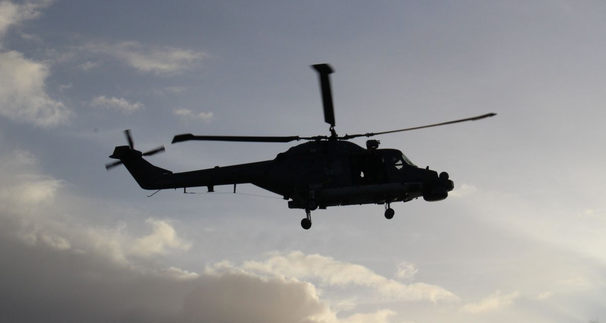 Die Silhouette eines Marinehubschraubers vor Wolkenspiel