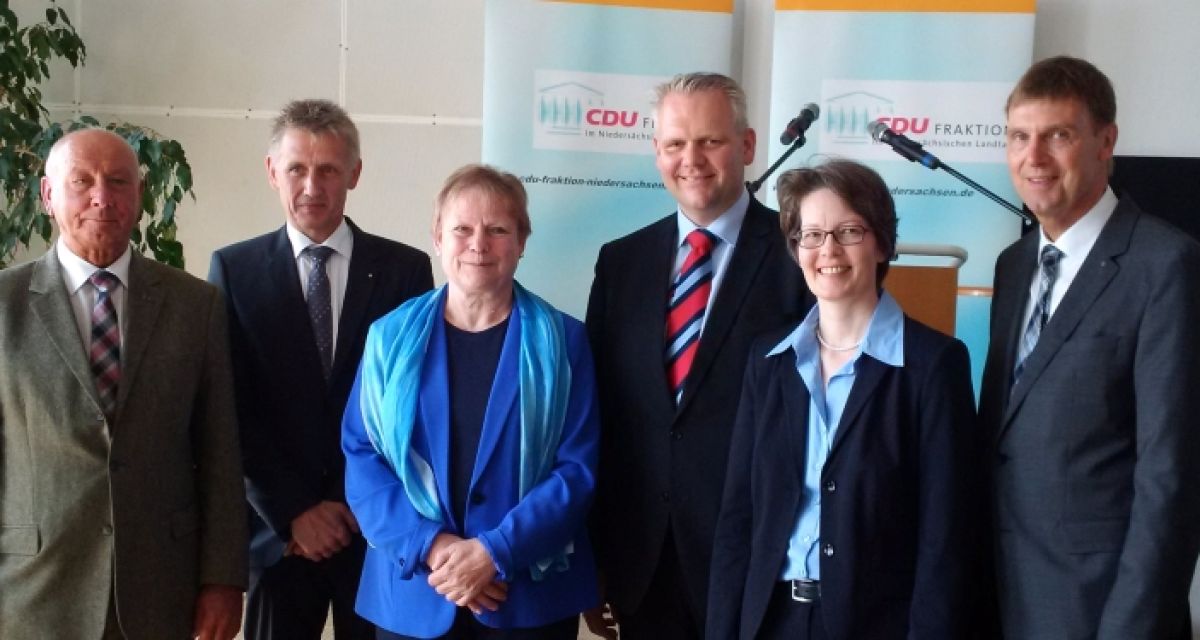 Viele lächelnde Menschen posieren für die Kamera.