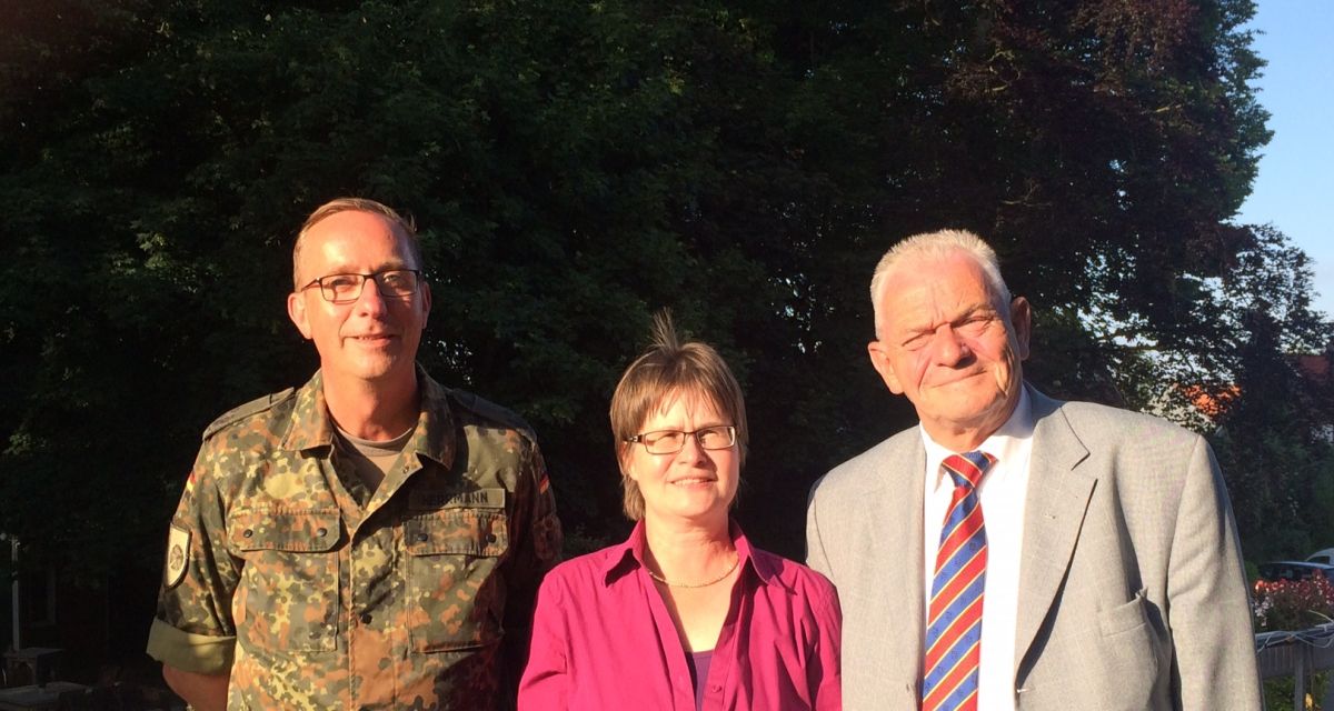 drei Menschen lächeln im Sonnenschein in die Kamera