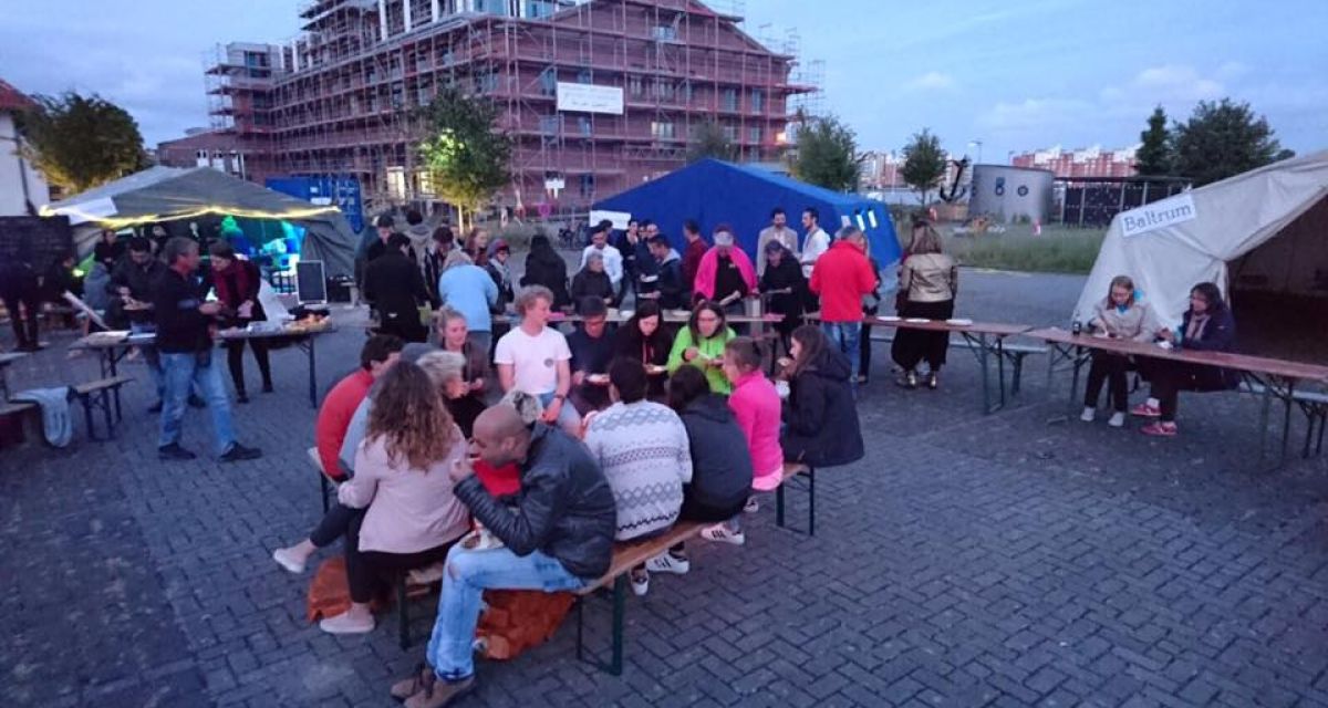 Am Wilhelmshavener Südstrand essen Menschen an Partytischen anlässlich des Integrationsfestivals.