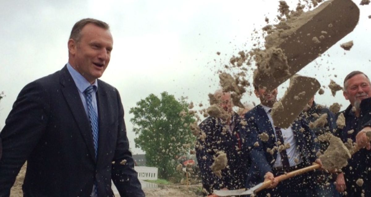 Männer werfen mit Spaten Sand durch die Luft