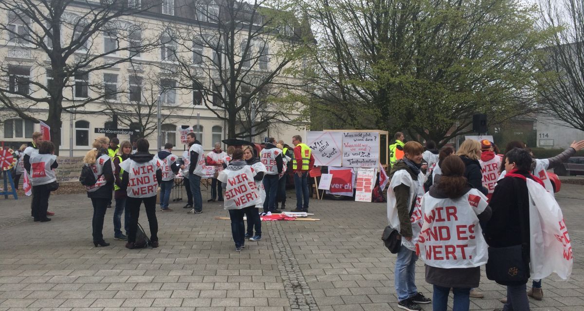Straßenzug. Viele Menschen von hinten, die streiken