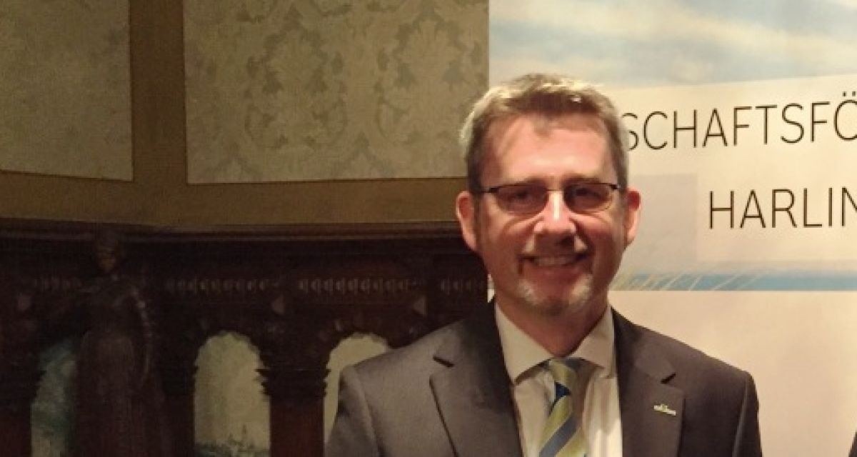 Ein Mann im Anzug lächelt in die Kamera