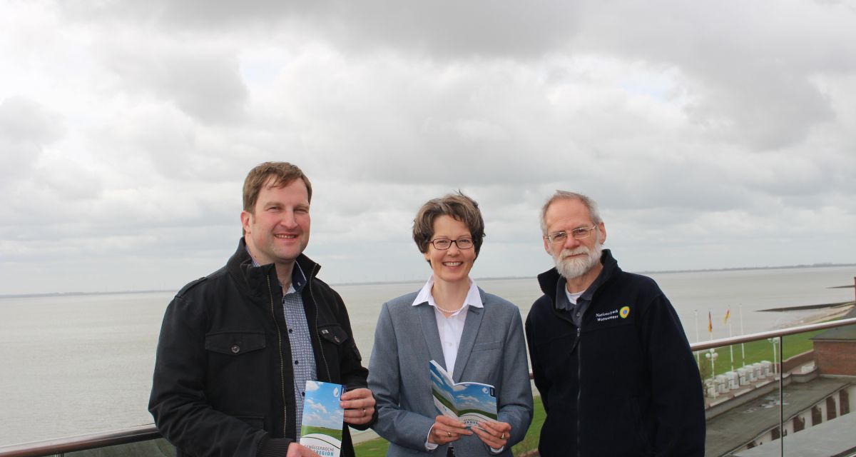 Drei Personen an der Küste