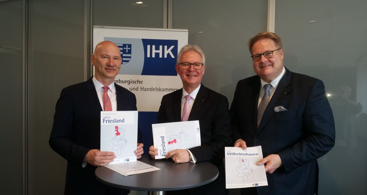 Drei Männer von der Ihk halten Unterlagen über eine Unternehmerumfrage in den Händen