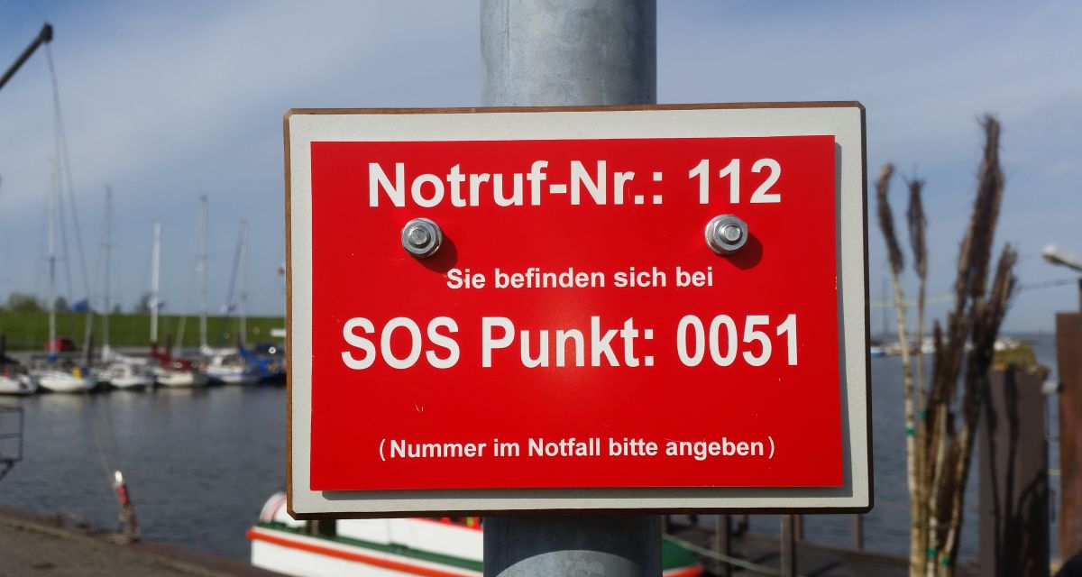 Auf einer roten Tafel steht in weißer Schrift: 